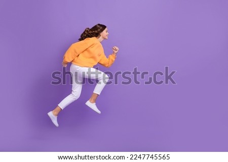 Full size profile portrait of excited crazy person jumping running empty space isolated on purple color background