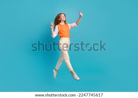 Photo of charming blogger pupil wear waistcoat record video make selfie photo face v-sign empty space isolated on blue color background