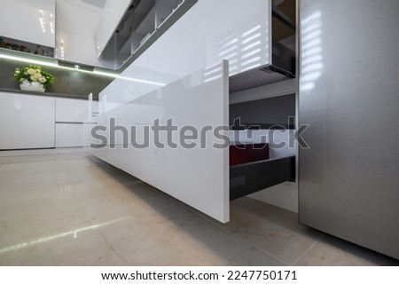 White modern kitchen, furniture details closeup to lower drawers pulled out Royalty-Free Stock Photo #2247750171