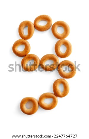 Number 9 bagel. Digit nine Bagels font. Alphabet from set of small dry bagels isolated on white background. ABC symbols.