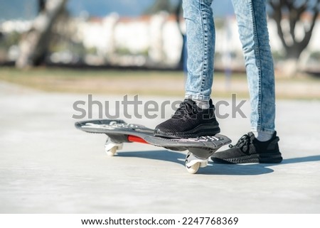Legs on waveboard close up, Girl riding on casterboard with two wheels, modern street skate sports of teenagers, ripstick for balance ride.