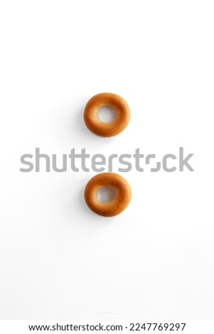 Symbol colon bagel. Bagels font. Alphabet from set of small dry bagels isolated on white background. ABC symbols.