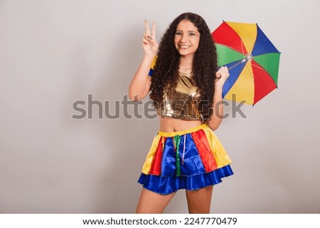young teen girl, brazilian, with frevo clothes, carnival. with umbrella sign of peace and love.