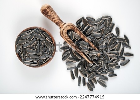 Black sunflower seeds in a bowl on white background,top view