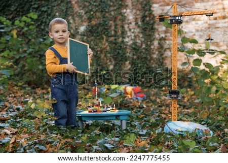 Little toddler boy playing with big yellow construction building crane toy. Child activity, creative game, using imagination