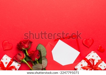 Valentine day composition with Envelope, rose flower and Red heart on table. Top view, flat lay. Holiday concept.