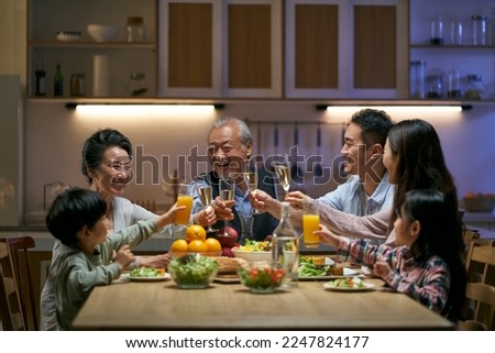 three generation asian family gathering at home celebrating holiday having a toast Royalty-Free Stock Photo #2247824177