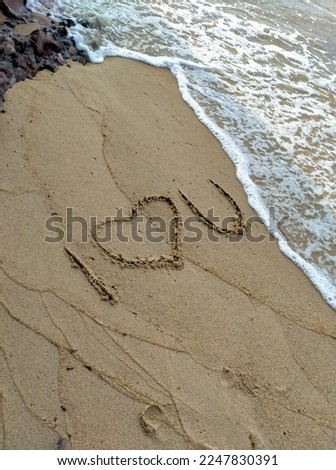Writing I Love You on the sand