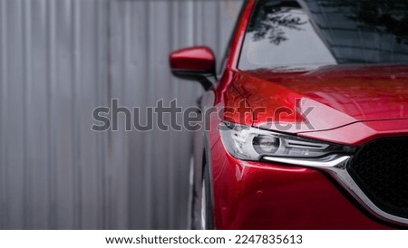close up headlight of red car against gray blurred background. Royalty-Free Stock Photo #2247835613