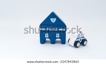 Close up of blue wooden police station and police car on white background. Wooden toys.