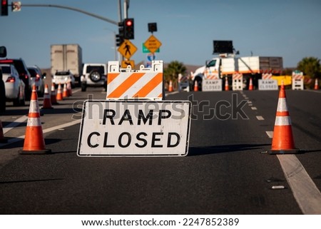 Traffic caused by a sign and cones indicating a freeway onramp is closed