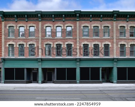 Row of old main street buildings with stores at ground level and apartments or offices above Royalty-Free Stock Photo #2247854959