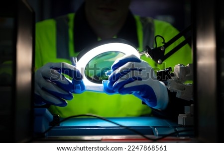 The technician must use bright lights and a magnifying glass to check the detail of the workpiece. the 3D printer's printout. Royalty-Free Stock Photo #2247868561