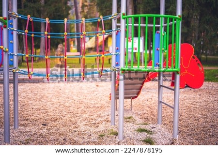 Colorful playground on yard in the park. Colorful children playground activities in public park surrounded by green trees