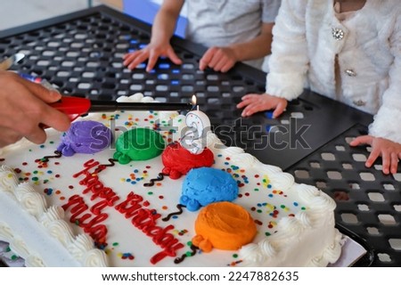 View of a number two candle on a birthday cake being lit up. Lighting up a birthday cake candle.