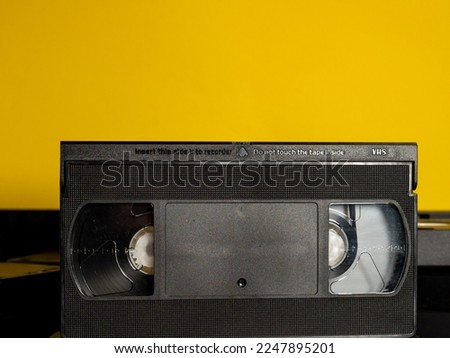 Old VHS cassettes on a yellow background. Retro video cassettes. Close-up.