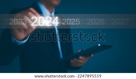 Happy new year 2024 hand touch on a virtual screen 2024. New Goals, Plans, and numbers for Next Year. Businessman touching future growth year 2023 to 2024. Planning, opportunity, business strategy. Royalty-Free Stock Photo #2247895519