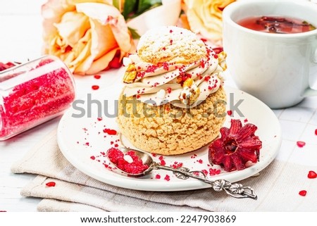 The concept of romantic tea. French Shu cake, hibiscus tea, bouquet of roses, festive decor. Valentine's Day concept, Women's Day March 8, Wedding. White boards background, close up