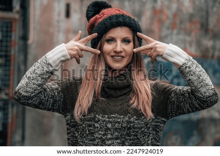 urban woman making peace gesture with her fingers in the street