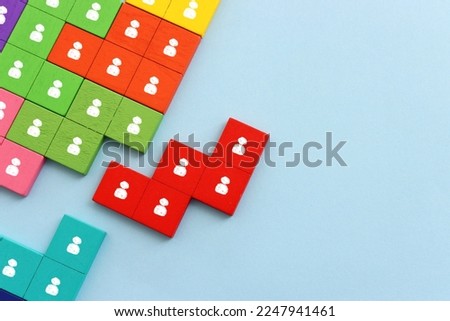 Business image of wooden tangram puzzle with people icons over blue background, human resources and management concept