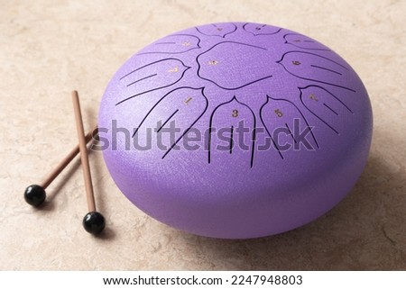 Tongue drum with drumsticks, Purple hang drum. music for relaxation and meditation. Royalty-Free Stock Photo #2247948803