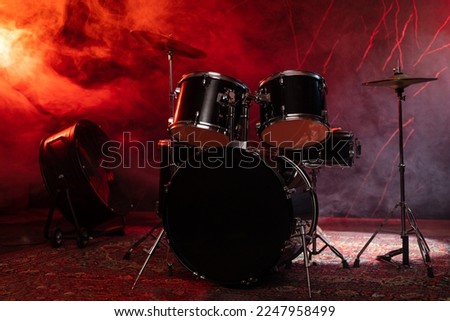 Drums and drum set. Beautiful blue and red background, with rays of light. Beautiful special effects of smoke and lighting. Musical instrument. The concept of music. Close-up photo. Royalty-Free Stock Photo #2247958499