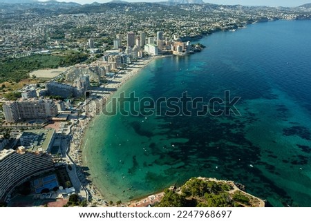 Aerial view breathtaking Penyal dIfac natural park of Penon de Ifach massive limestone on the Mediterranean sea, moored vessels on port of Calpe. Sunny day picturesque landscape. Costa Blanca Spain