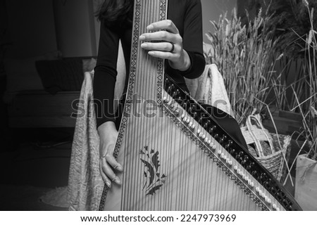 black and white classic photo, learning music, young girl plays ukrainian folk instrument, bandura, hands and strings close up