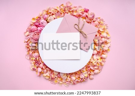 White round podium, craft pink envelope, blank card, rose petals and buds layout on a pink background.Valentines Day background and Copy space for your text. Card design. Ad space.