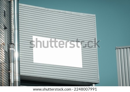 Blank white advertising billboard, information board mockup on industrial warehouse, factory building wall