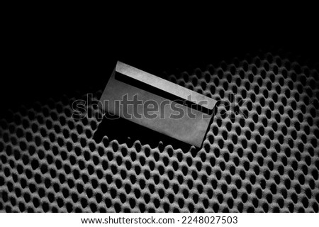 Branding envelope DL mockup template on a black soundproof foam background and deep shadows, real photo. Blank isolated to place your design. 