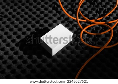 Branding business cards mockup template on a black soundproof foam background with orange wire and deep shadows, real photo. Blank isolated to place your design. 