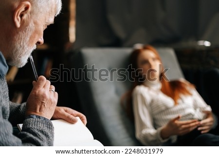 Unrecognizable red-haired young woman patient talking about problems while lying in comfortable sofa during psychological consultation. . Concept of psychological treatment. Royalty-Free Stock Photo #2248031979