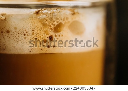 Close-up of a cappuccino. Coffee with foam in a transparent cup. Macro.