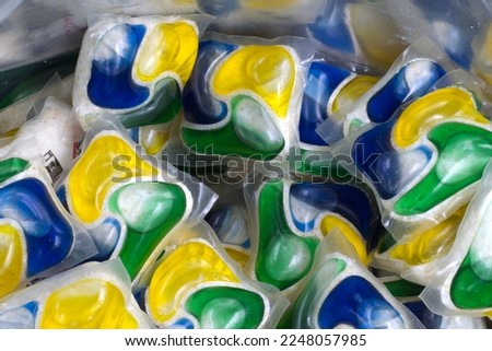 Laundry detergent pods for dischwashing machine in pack. Yellow, green and blue detergent 