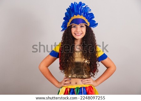 young teen girl, brazilian, with frevo clothes, carnival. wearing feather headdress posing for photo.
