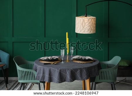 Beautiful table setting with candles in stylish room