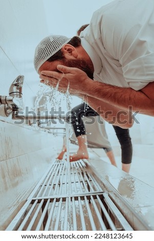 A Muslim performing ablution. Ritual religious cleansing of Muslims before performing prayer. The process of cleansing the body before prayer Royalty-Free Stock Photo #2248123645