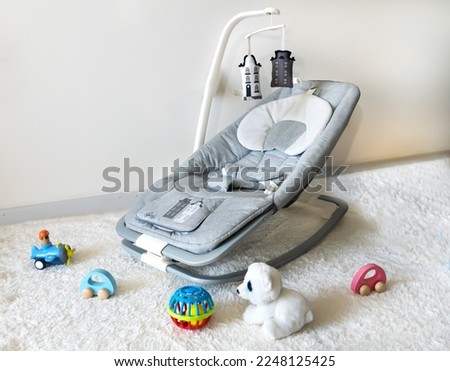 Baby rocker and toys in baby playroom  Royalty-Free Stock Photo #2248125425