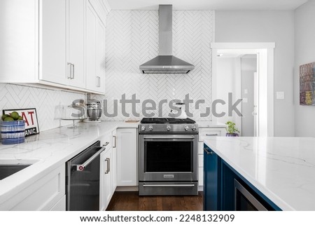 Styled Kitchen Interior. Stylish White Neutral Kitchen. White Cabinets with Stainless Steel Appliances and Tile Backsplash. Kitchen Interior Design. Royalty-Free Stock Photo #2248132909