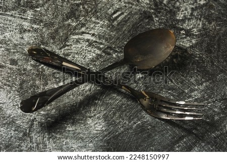 Set of kitchen utensils forks, spoons, knife on a dark background