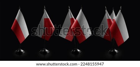 Small national flags of the Poland on a black background.