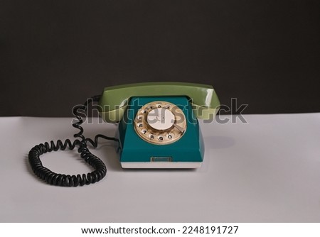 an old disk phone on a white table. High quality photo