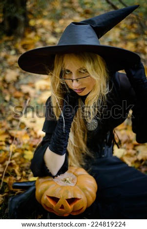 Halloween, girl in witch dress with pumpkin