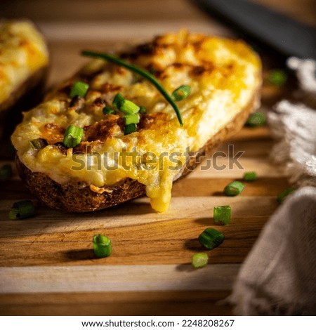 Cheesy twice-baked potato garnished with chopped scallion. Royalty-Free Stock Photo #2248208267