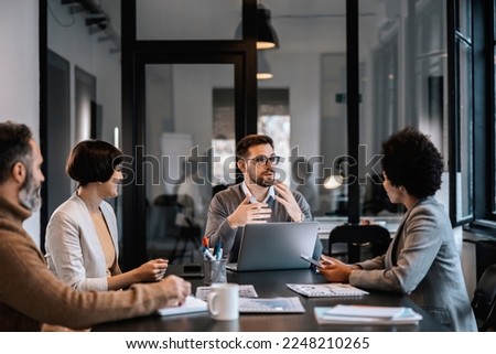 A focused mentor is explaining project to mentees at the boardroom at enterprise. Royalty-Free Stock Photo #2248210265