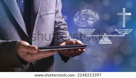 Choice between religion and rationality. On the scales of the cross and brains from the network. Man holding a tablet in his hand