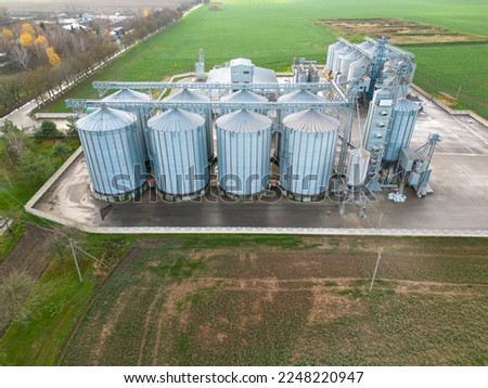 silver silos on agro manufacturing plant for processing drying cleaning and storage of agricultural products, flour, cereals and grain. Flying a drone over iron barrels of grain. quadcopter photo
