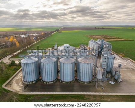 Drone flight over a large agro-industrial complex and barrels of grain. silos at the agro manufacturing plant for processing, drying, cleaning and storage of agricultural products, flour, cereals