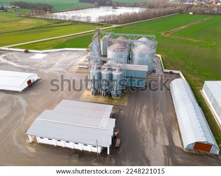 silver silos on agro manufacturing plant for processing drying cleaning and storage of agricultural products, flour, cereals and grain. Flying a drone over iron barrels of grain. quadcopter photo